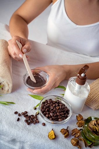 Young woman mixing ingredients for coffee facial mask for skin scrub treatment