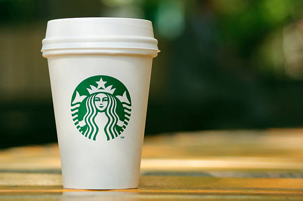 Tall Starbucks to go cup on wooden table