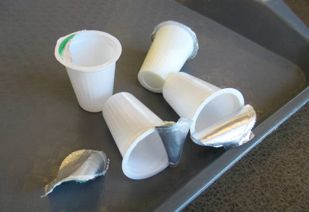 Lifestyle...This is a close up shot of several small, used, plastic milk cups, lying on a coffee tray. Probably Thermoplastic.