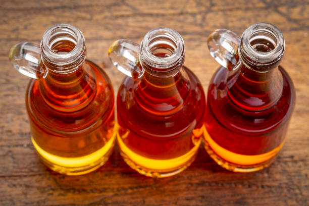 sampler of pure maple syrup (golden, amber and gold) - small glass bottles against rustic wood