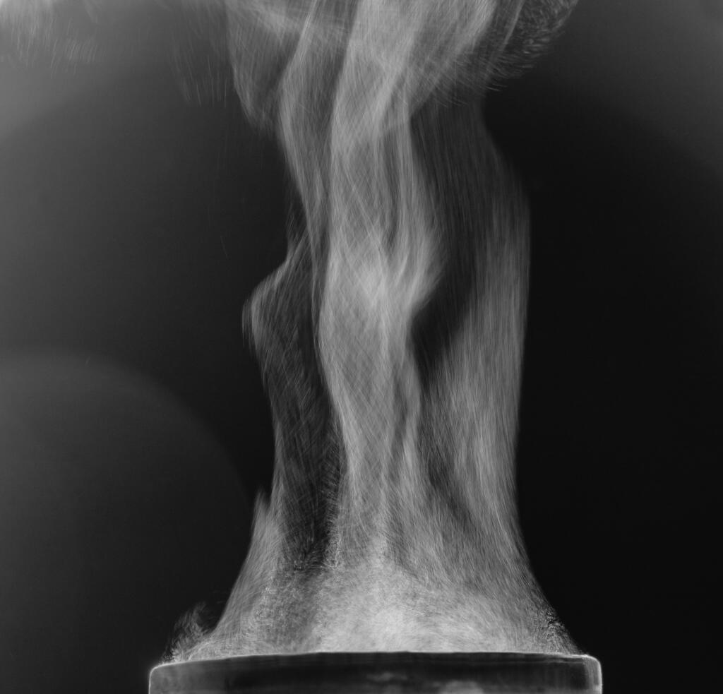 The movement of steam over the cup. Liquid evaporation. Black and white.