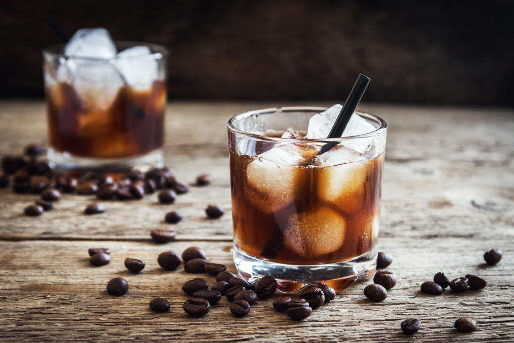 Black Russian Cocktail with Vodka and Coffee Liquor. Homemade Alcoholic Boozy Black Russian drink with coffee beans on wooden background with copy space.