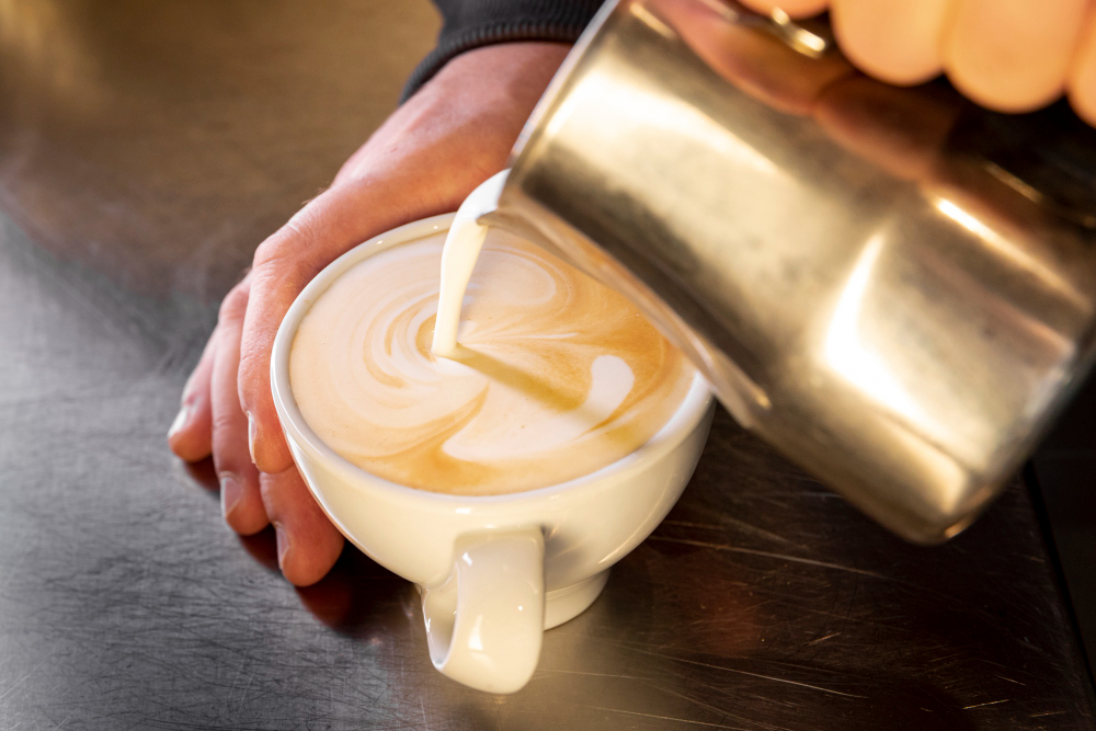close-up barista pouring coffee into cup